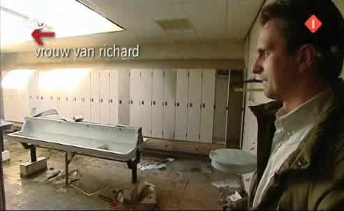 Richard werpt een blik in de vieze wasruimte, maar kan vanuit deze positie niet zien dat er nog een deur zit.